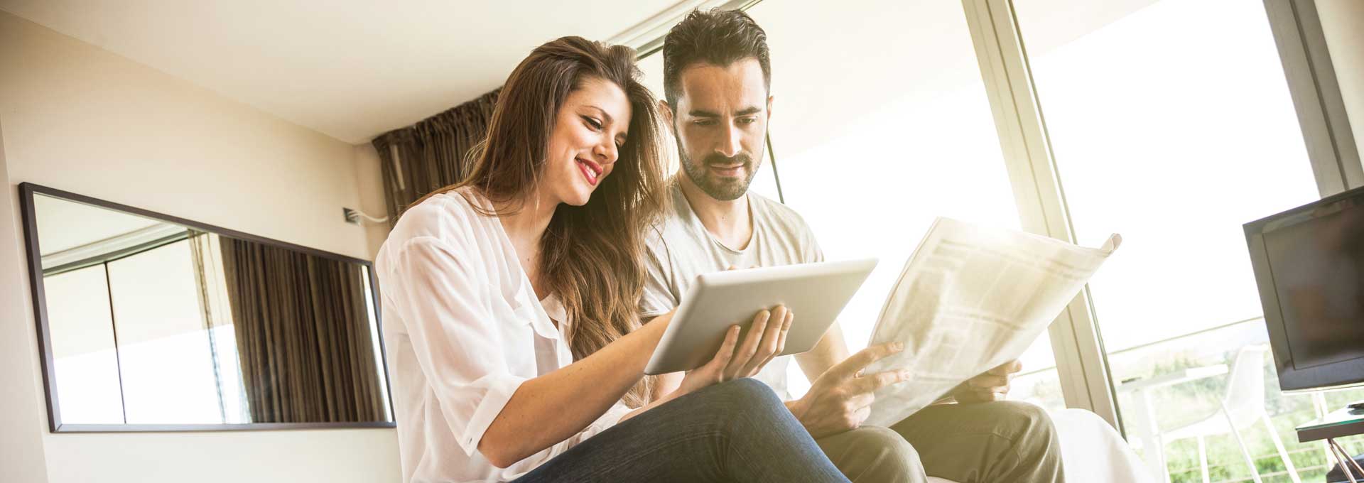 People reading newspaper and tablet